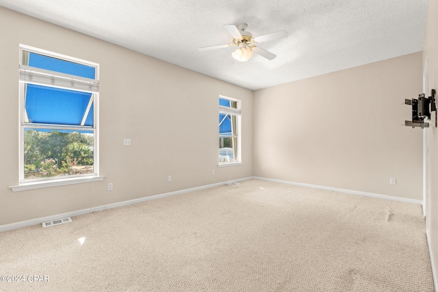 empty room featuring carpet, ceiling fan, and a textured ceiling