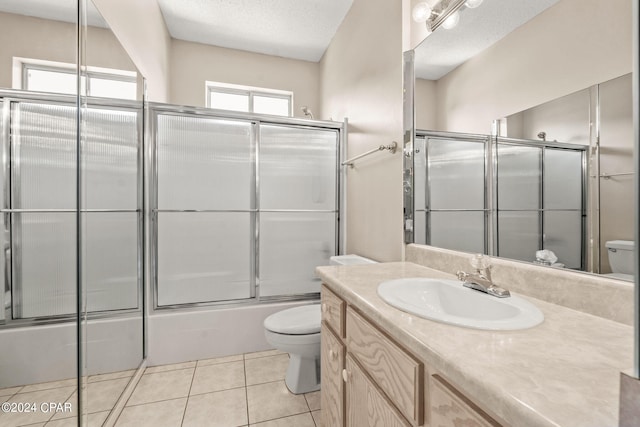 full bathroom featuring combined bath / shower with glass door, vanity, toilet, and tile patterned flooring