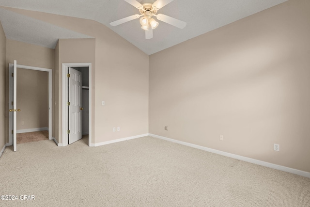 unfurnished bedroom featuring vaulted ceiling, ceiling fan, and light colored carpet