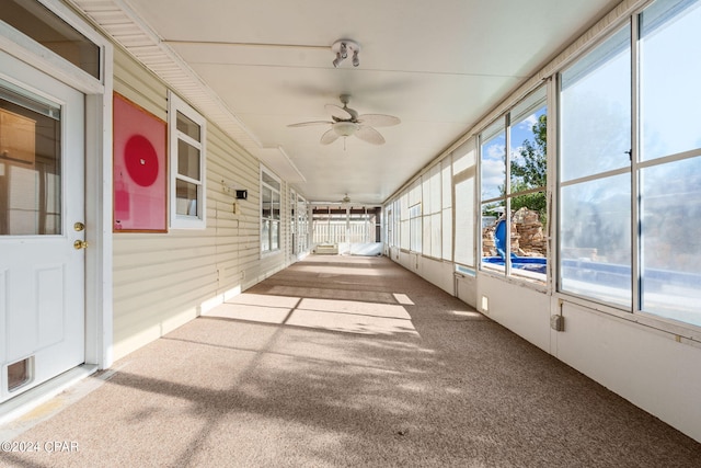 unfurnished sunroom featuring ceiling fan