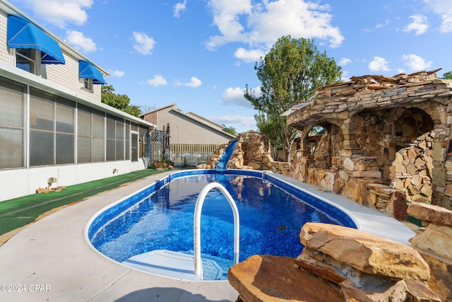 view of swimming pool featuring a sunroom