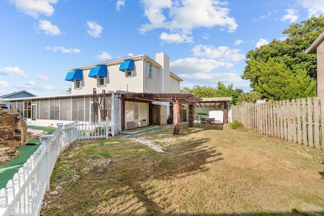 rear view of property featuring a yard, a sunroom, and a pergola