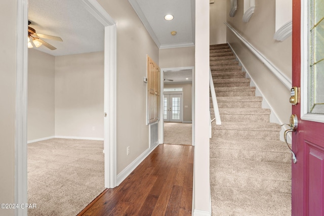 stairs featuring ceiling fan, hardwood / wood-style flooring, french doors, and ornamental molding