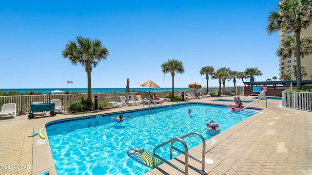 view of pool with a water view and a patio area