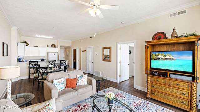 living room with ceiling fan, ornamental molding, a textured ceiling, and dark hardwood / wood-style flooring