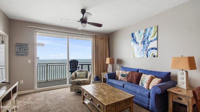 carpeted living room with a water view and ceiling fan