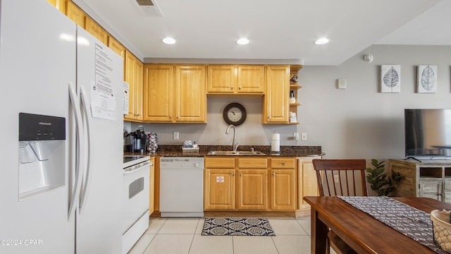 kitchen featuring dark stone countertops, white appliances, sink, and light tile patterned flooring