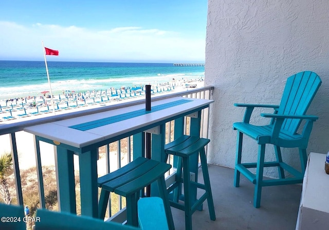 balcony featuring a water view and a beach view