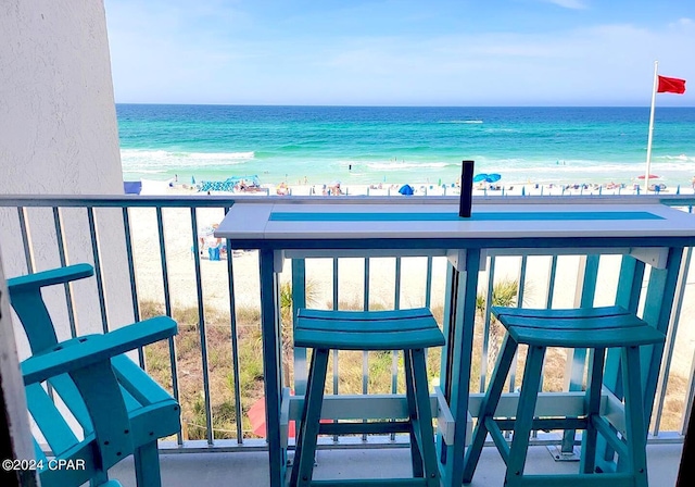 balcony with a water view and a beach view