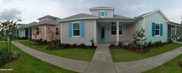 view of front of house featuring ceiling fan and a front yard