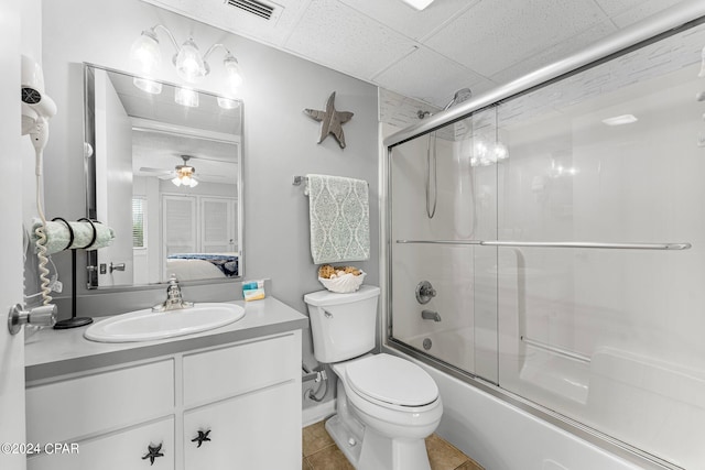 full bathroom with ceiling fan, shower / bath combination with glass door, vanity, tile patterned floors, and toilet