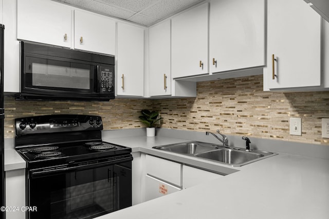 kitchen featuring white cabinets, a drop ceiling, sink, and black appliances