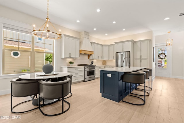 kitchen with decorative light fixtures, high end appliances, a notable chandelier, and custom exhaust hood