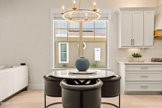 dining area featuring light wood-type flooring and an inviting chandelier