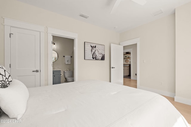 bedroom featuring ensuite bathroom, ceiling fan, and light wood-type flooring