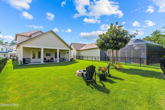 back of house with a lawn, glass enclosure, and french doors