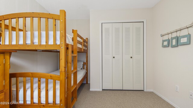 carpeted bedroom with a nursery area and a closet