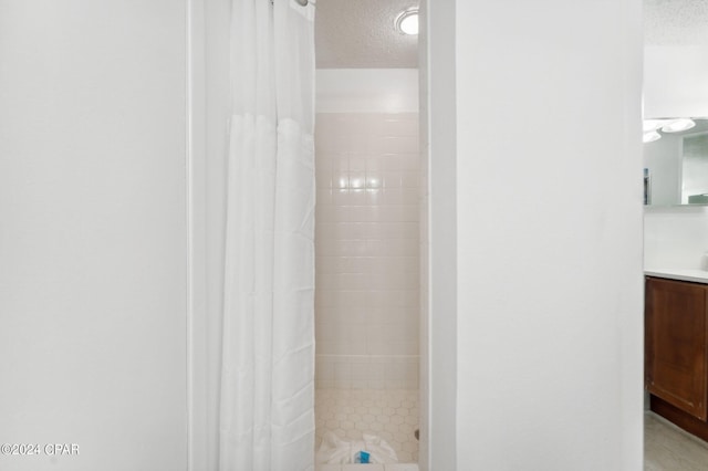 23223 Front Beach Rd Ph 4, Panama City Beach, FL 32413 - full bathroom featuring a textured ceiling, a stall shower, and vanity