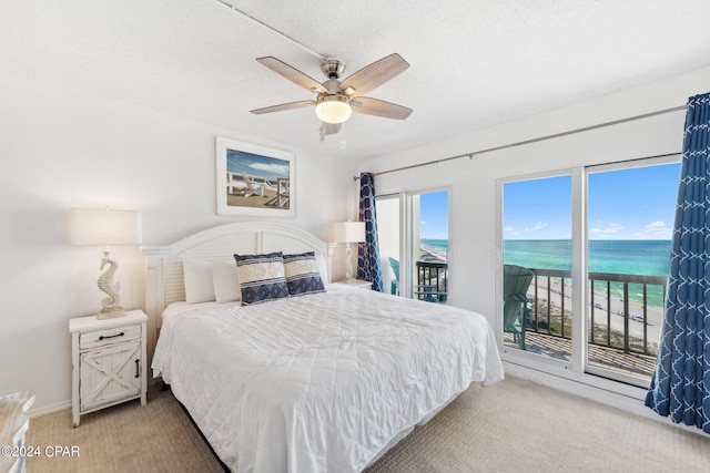 bedroom with a water view, ceiling fan, access to exterior, and carpet floors