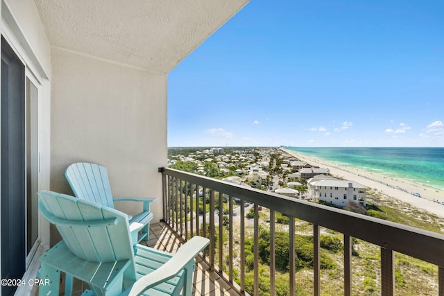 balcony featuring a water view and a beach view