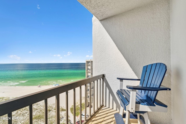 balcony with a water view and a view of the beach