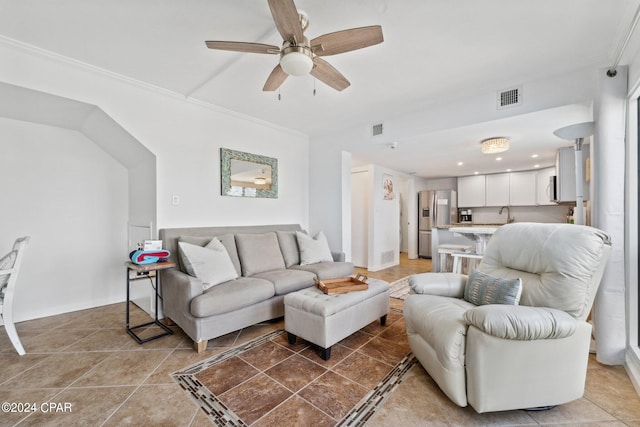 tiled living room featuring crown molding, sink, and ceiling fan