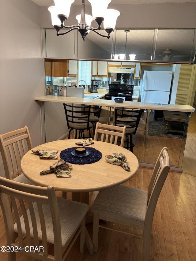 dining area featuring light wood-type flooring and a notable chandelier