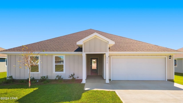 single story home featuring board and batten siding, a front yard, concrete driveway, and an attached garage