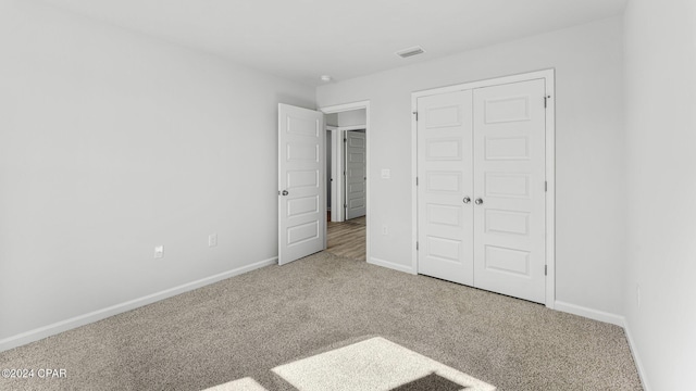 unfurnished bedroom with a closet, carpet flooring, and baseboards