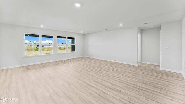 unfurnished room featuring light wood-style flooring, baseboards, and recessed lighting