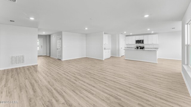 unfurnished living room featuring light wood-style flooring, visible vents, baseboards, and recessed lighting