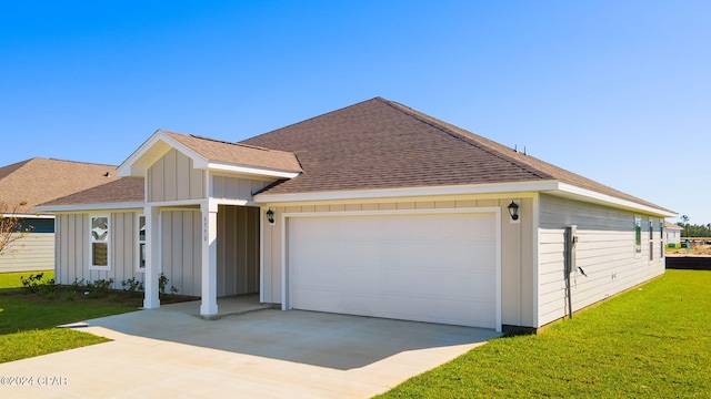 ranch-style house featuring a shingled roof, concrete driveway, an attached garage, board and batten siding, and a front lawn