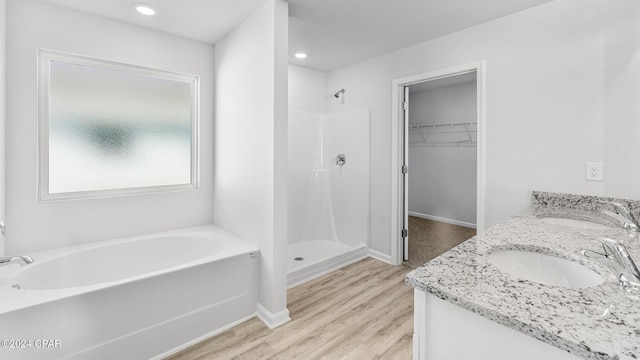 bathroom featuring a sink, a shower stall, a bath, and wood finished floors