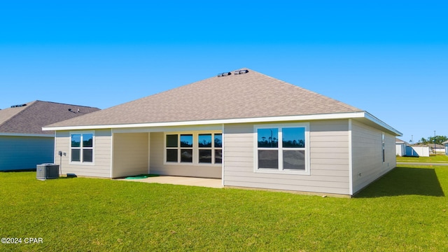 back of property featuring a patio area, roof with shingles, central AC unit, and a yard