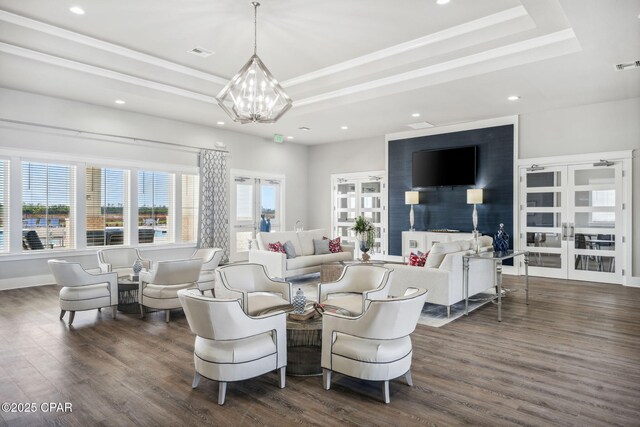 living area featuring a healthy amount of sunlight, a raised ceiling, and dark wood-style flooring