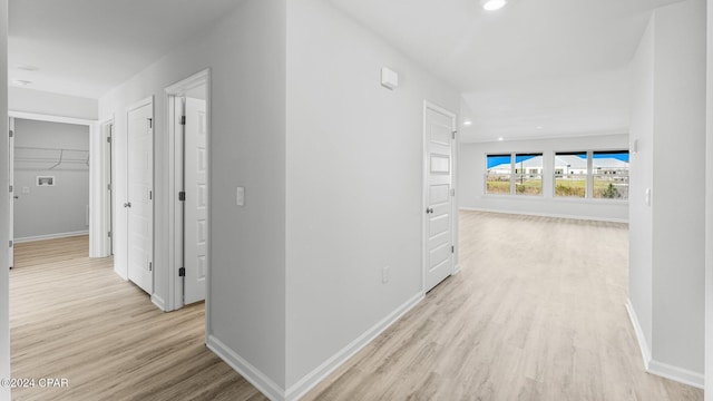 hallway with light wood-style floors, recessed lighting, and baseboards