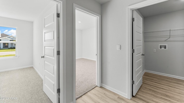 hallway with light wood-type flooring and baseboards