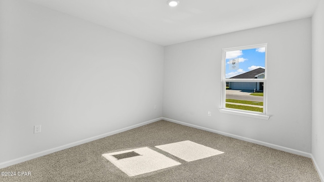 unfurnished room featuring carpet and baseboards