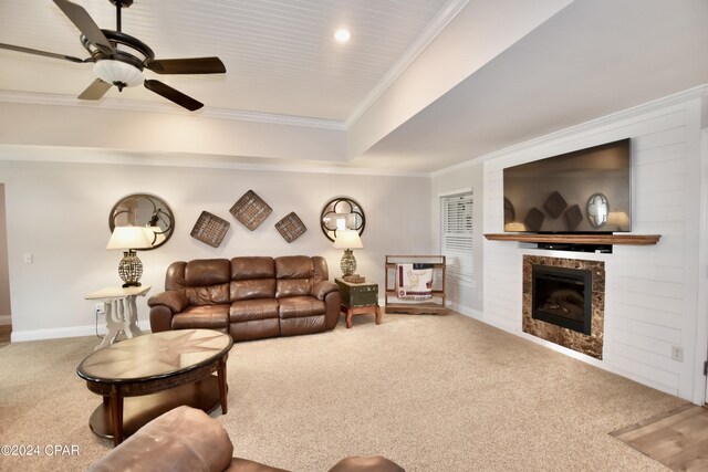 living room featuring ceiling fan, ornamental molding, and carpet