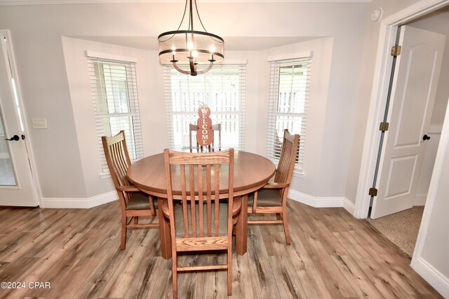 dining space with an inviting chandelier and light hardwood / wood-style flooring