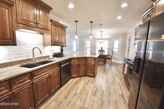 kitchen with sink, kitchen peninsula, hanging light fixtures, light hardwood / wood-style flooring, and black appliances