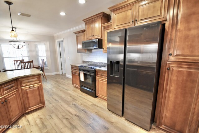 kitchen with light wood-type flooring, a chandelier, hanging light fixtures, stainless steel appliances, and crown molding