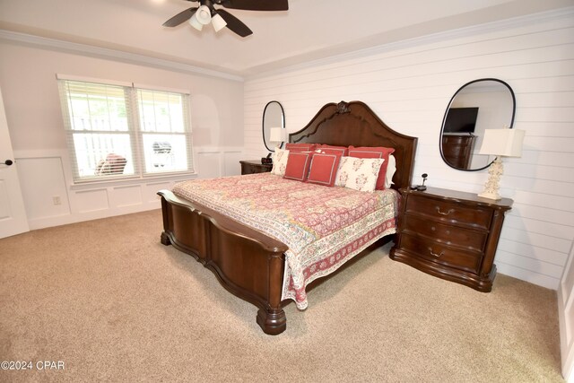 carpeted bedroom featuring ceiling fan and crown molding