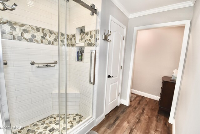 bathroom featuring an enclosed shower, ornamental molding, and hardwood / wood-style flooring