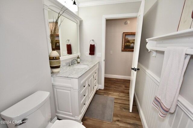 bathroom featuring ornamental molding, vanity, toilet, and hardwood / wood-style flooring