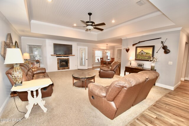 living room featuring ceiling fan, a raised ceiling, crown molding, and hardwood / wood-style floors