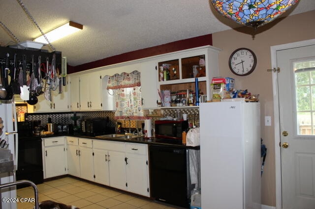 kitchen with a textured ceiling, black appliances, white cabinetry, and decorative backsplash