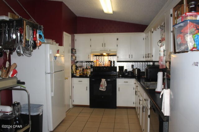 kitchen with white cabinets, vaulted ceiling, and electric range