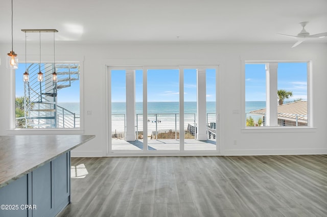 interior space with a water view, plenty of natural light, and ceiling fan