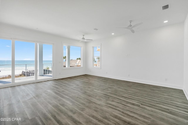 spare room featuring dark wood-style floors, recessed lighting, visible vents, a ceiling fan, and baseboards